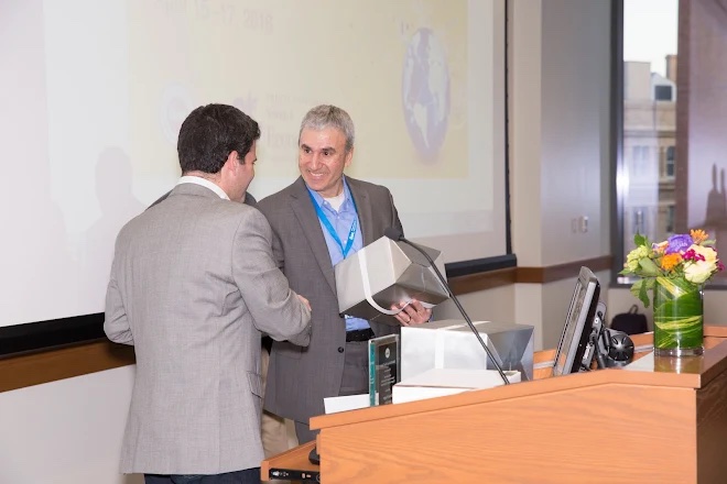 Receiving an appreciation gift from the president of the Industrial Organization Society (IOS), Prof. Marc Rysman, for serving as chair of the local organizing committee.